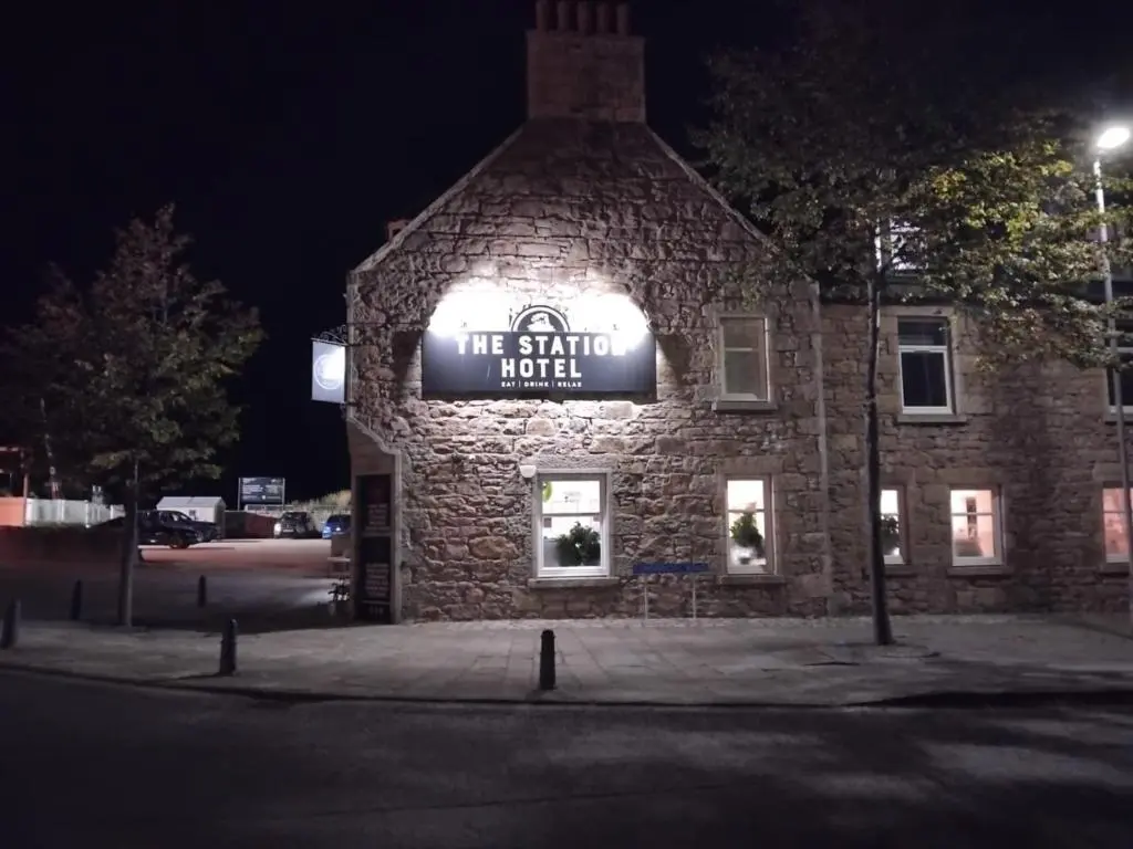 a stone building with a sign on it at night at The Station Hotel Insch in Insch