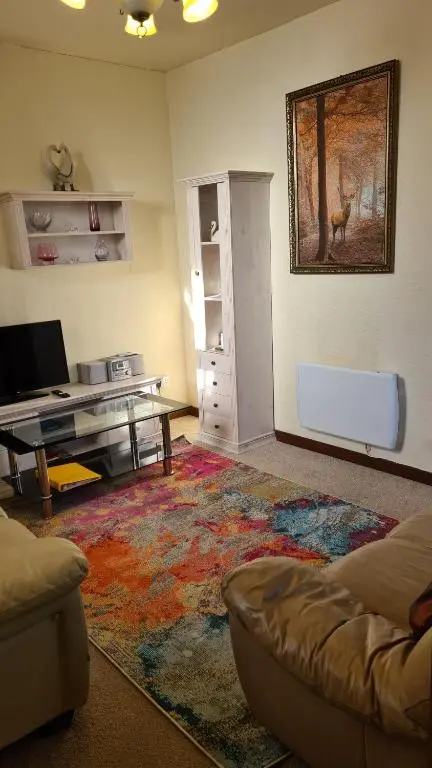 a living room with a couch and a table at Skye Cottage, Meadowside House, near Kingussie in Kingussie