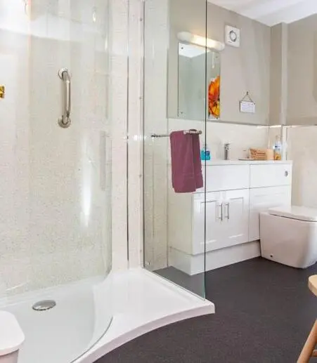 a white bathroom with a shower and a toilet at Roe Deer Cottage in Beauly