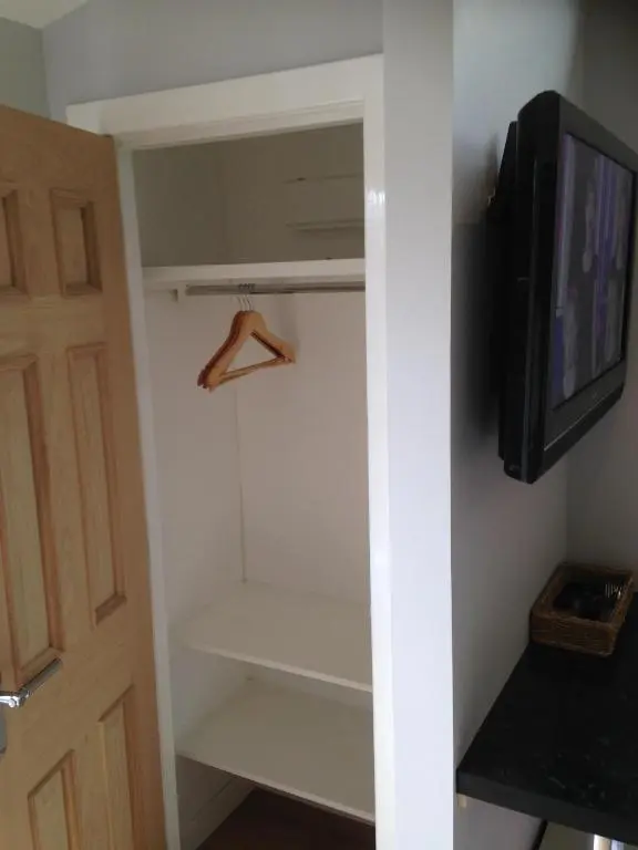 a walk in closet with a tv and a hanger at ensuite garden room in Inverness