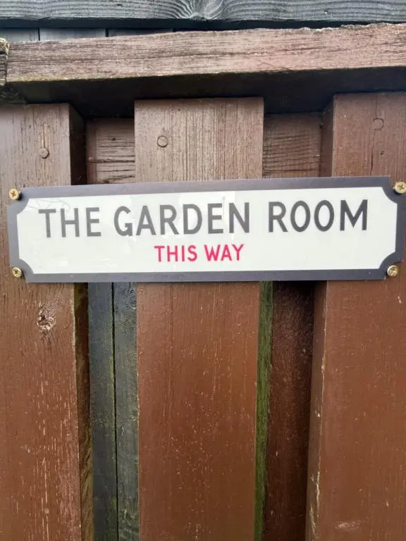 a sign that says the garden room this way on a wooden fence at ensuite garden room in Inverness