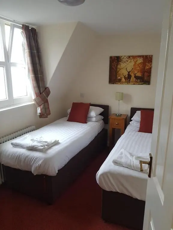 a bedroom with two beds and a window at The Station Hotel in Alness