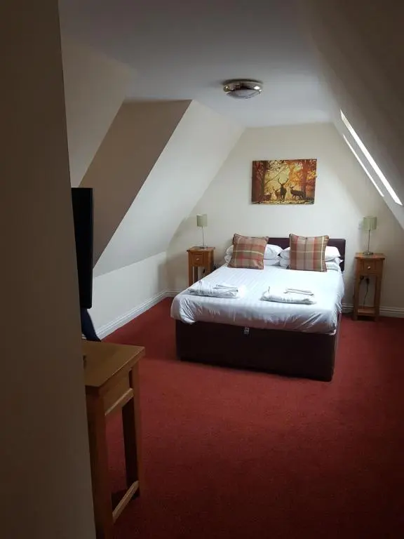 a bedroom with a large bed in a attic at The Station Hotel in Alness