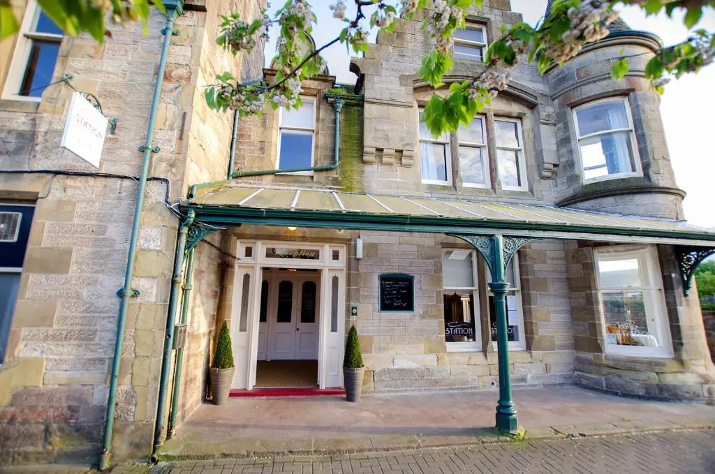 an old stone house with a white door at The Station Hotel in Alness