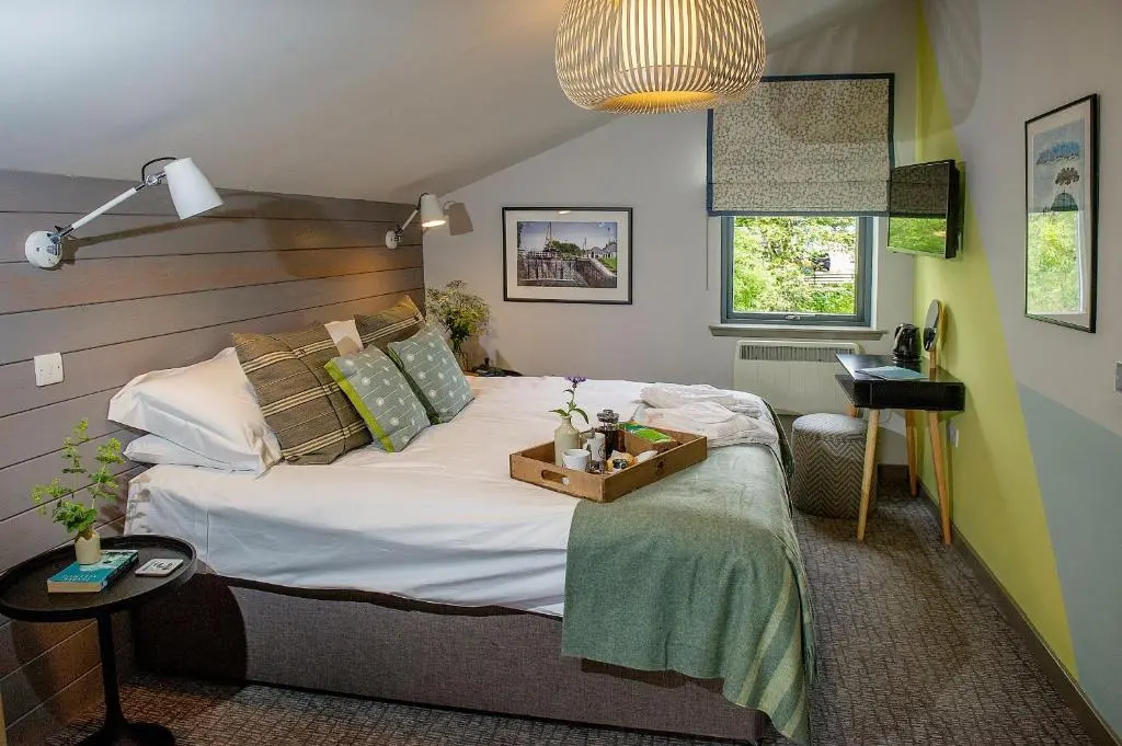 a bedroom with a large bed with a wooden headboard at Lock Chambers, Caledonian Canal Centre in Fort Augustus