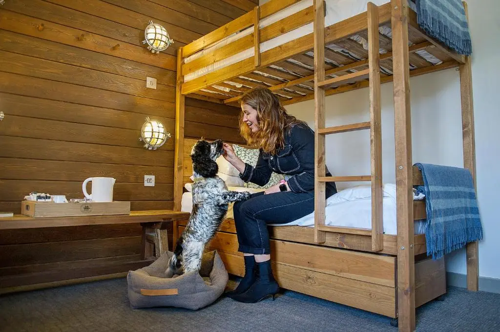 a woman playing with a dog in a bunk bed at Lock Chambers, Caledonian Canal Centre in Fort Augustus