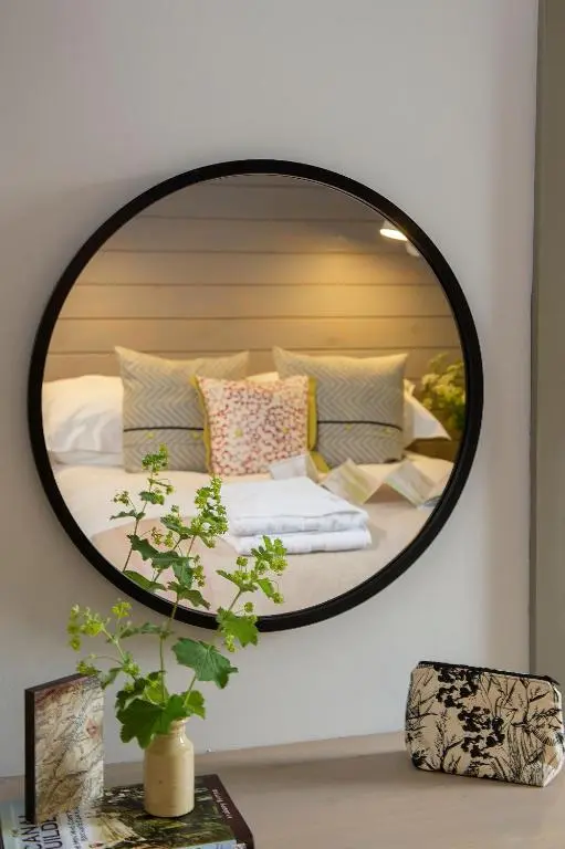 a mirror on a wall with a bed in a room at Lock Chambers, Caledonian Canal Centre in Fort Augustus