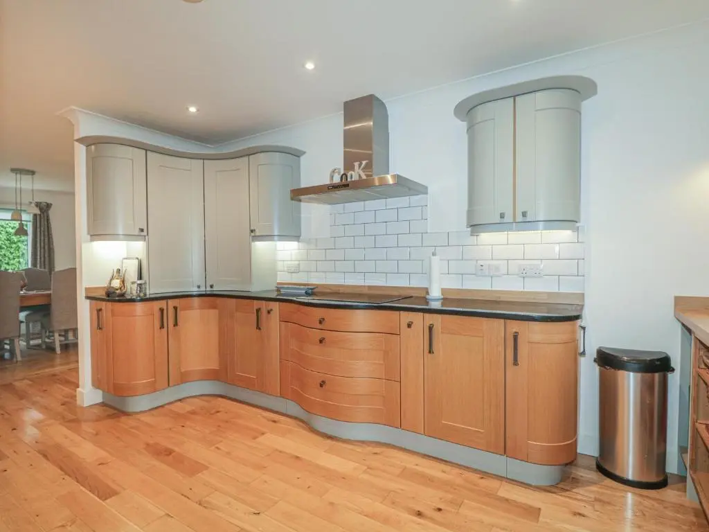 a kitchen with wooden cabinets and wooden floors at Number 11 in Beauly