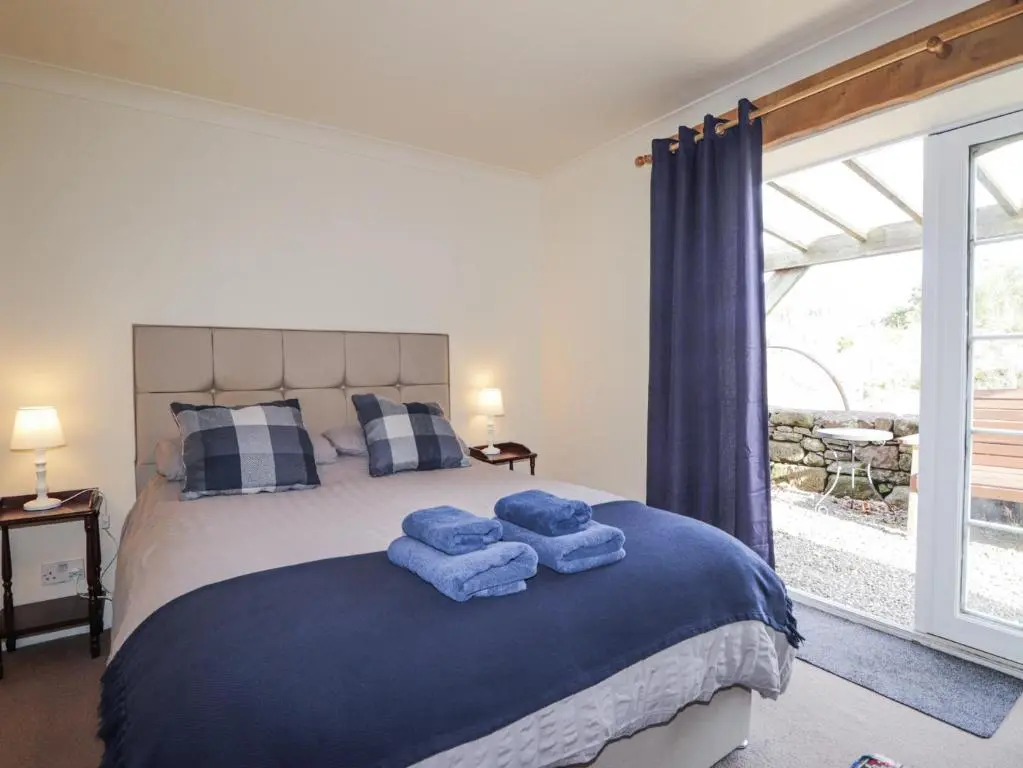 a bedroom with a bed with blue towels on it at The Orangery in Turriff