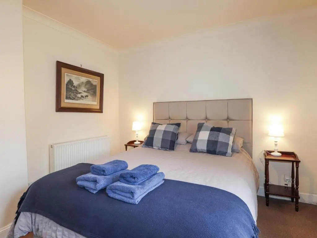 a bedroom with a bed with blue towels on it at The Orangery in Turriff