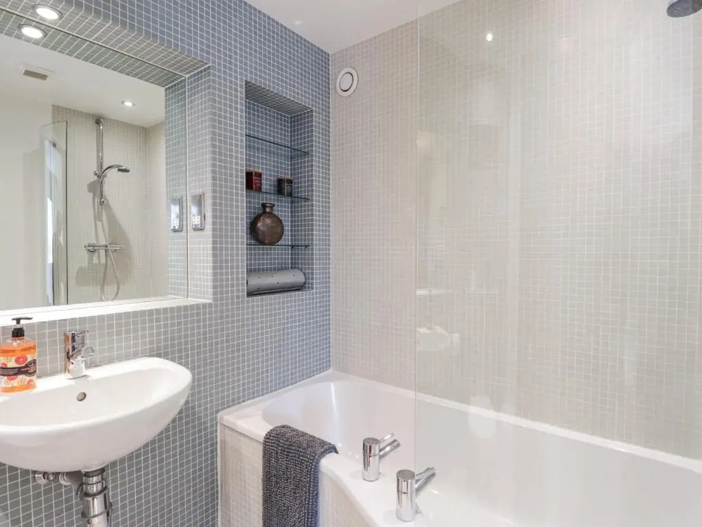 a bathroom with a white tub and a sink at The Orangery in Turriff