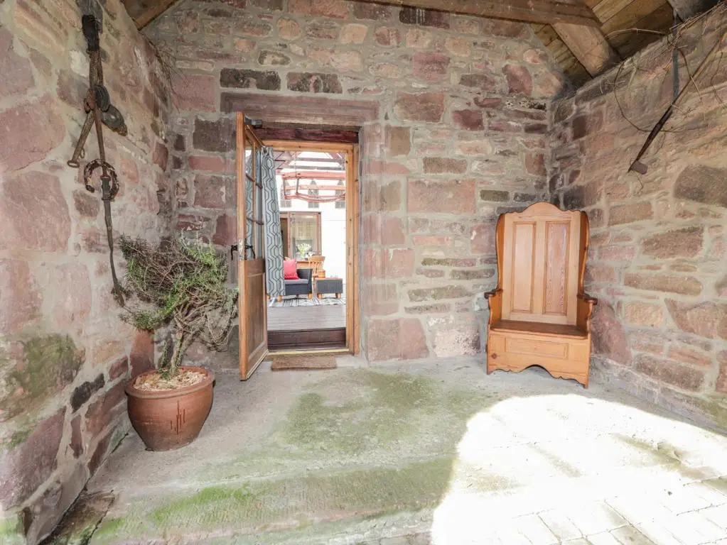 a stone room with a door and a plant in it at The Orangery in Turriff