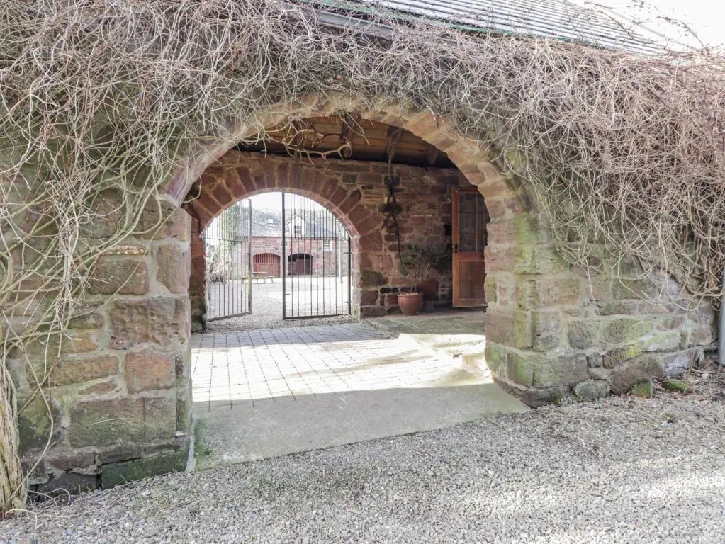 an archway in a brick building with a gate at The Orangery in Turriff