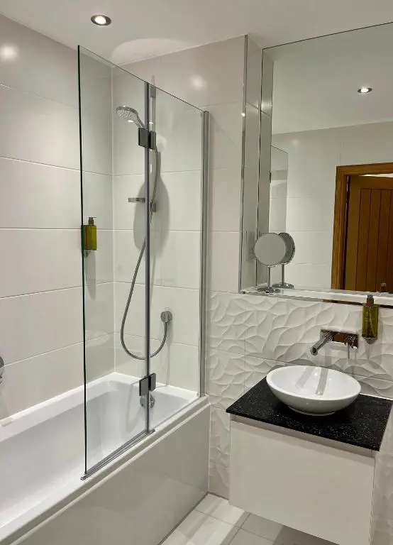 a white bathroom with a sink and a shower at Royal Golf Apartments in Dornoch