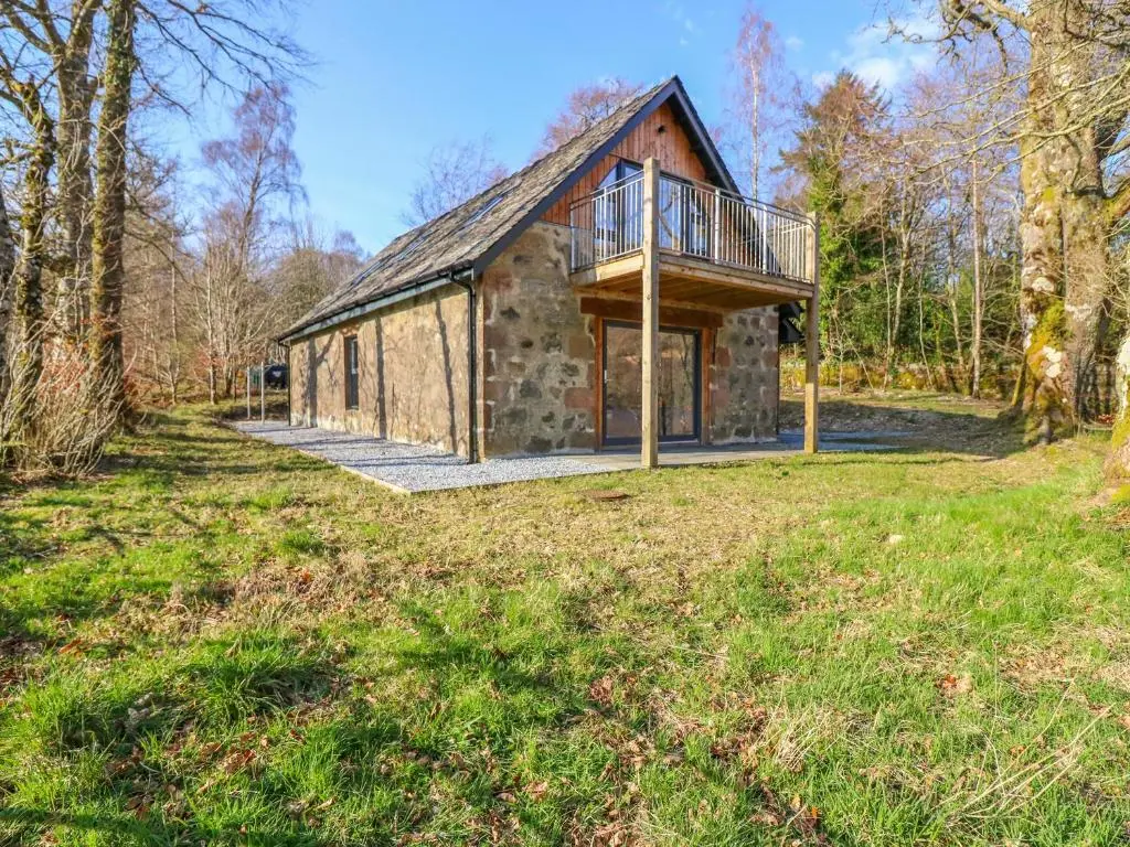 a stone house with a balcony on the front of it at Boat House in Invergarry
