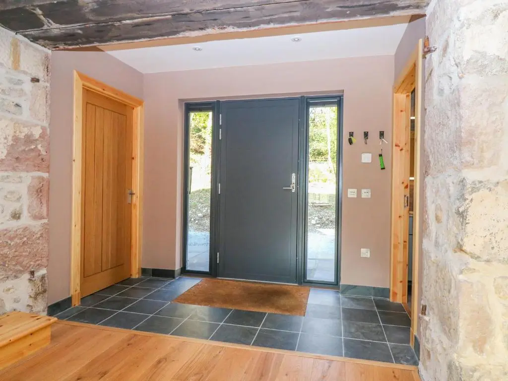 a door in a room with a stone wall at Boat House in Invergarry