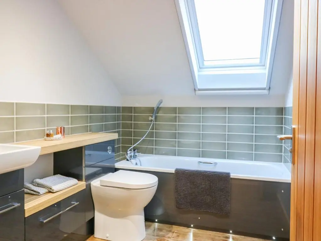 a bathroom with a toilet and a bath tub at Boat House in Invergarry