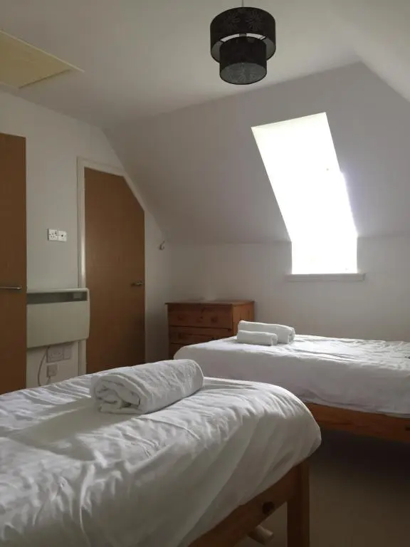 a bedroom with two beds and a window at Heathfield Highland Estate in Invergordon