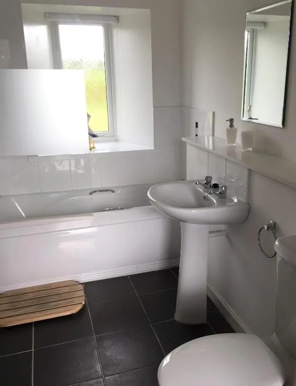 a white bathroom with a sink and a toilet at Heathfield Highland Estate in Invergordon