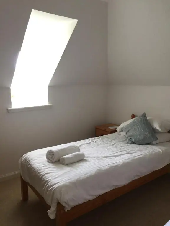 a bedroom with a bed with two towels on it at Heathfield Highland Estate in Invergordon