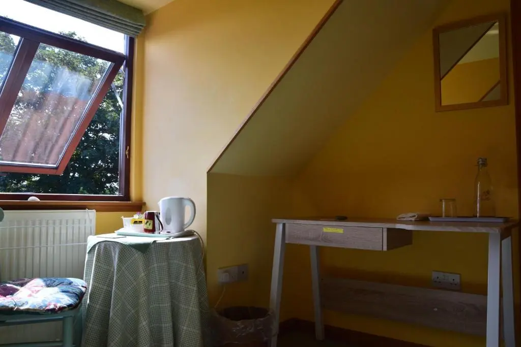 a room with a staircase with a table and a window at Sunflower Bed & Breakfast in Findhorn
