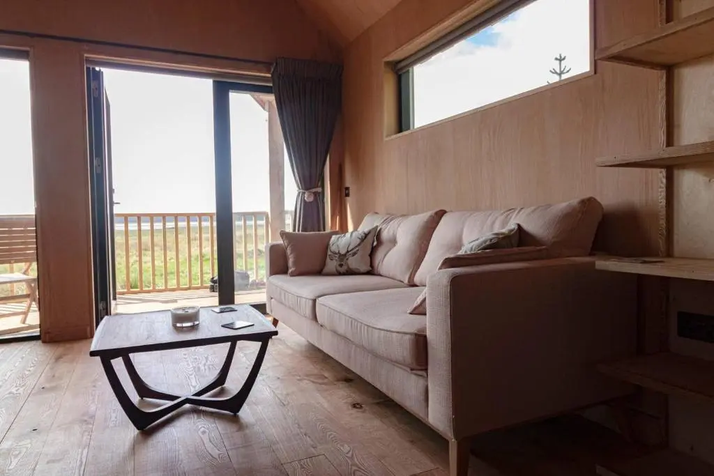 a living room with a couch and a table at Birdwatcher's Cabin in Golspie