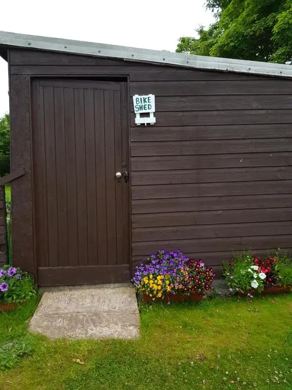a garage with a sale sign on the door and flowers at Helmsdale Lodge Hostel - all rooms en-suite in Helmsdale