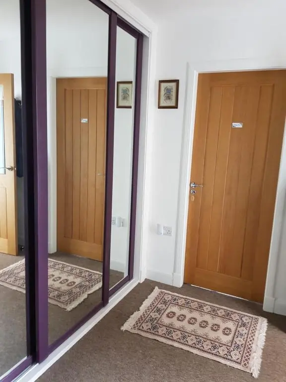 a hallway with two mirrors and two doors at Delny Muir House in Invergordon