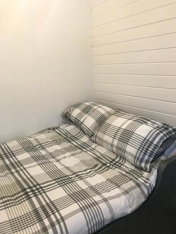 an unmade bed in a corner of a room at Star Cabin Lairg in Lairg