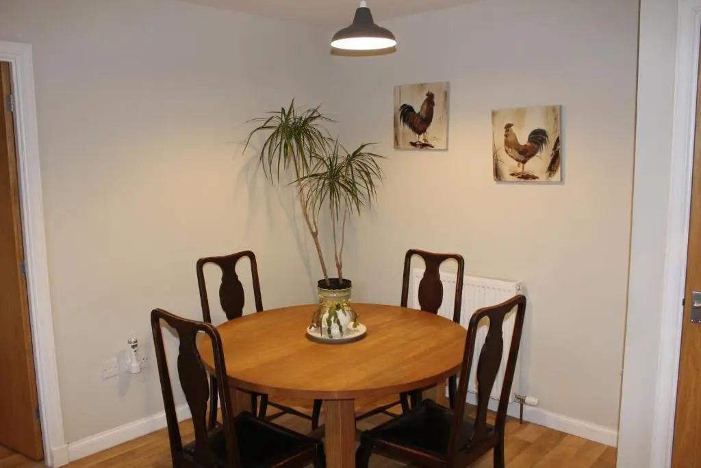 a dining room table with a plant in a vase at Roualeyn in Huntly