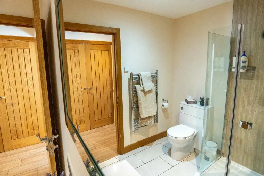 a bathroom with a toilet and a glass shower at Drumlochy B&B in Inverness