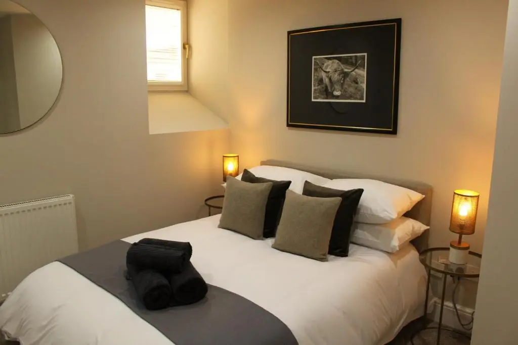 a bedroom with a large white bed with two lamps at The Bell Tower in Inverness