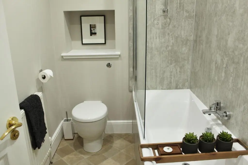 a bathroom with a toilet and a glass shower at The Bell Tower in Inverness