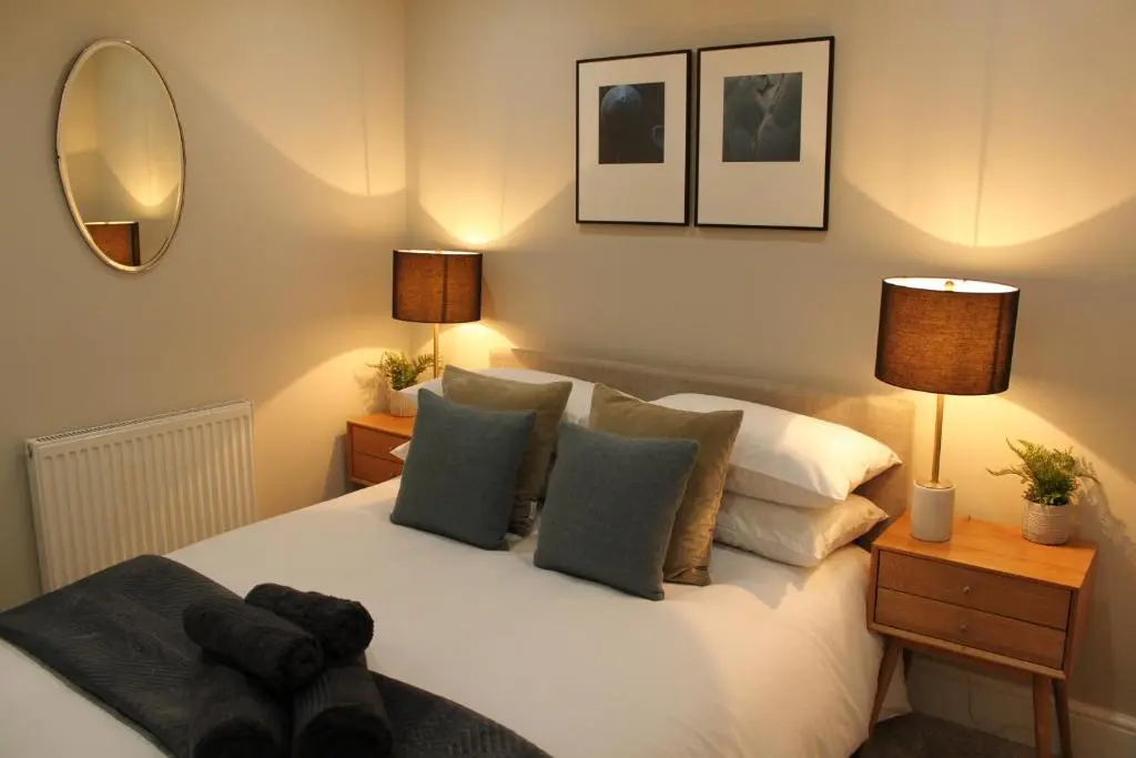 a bedroom with a bed with pillows and a mirror at The Bell Tower in Inverness