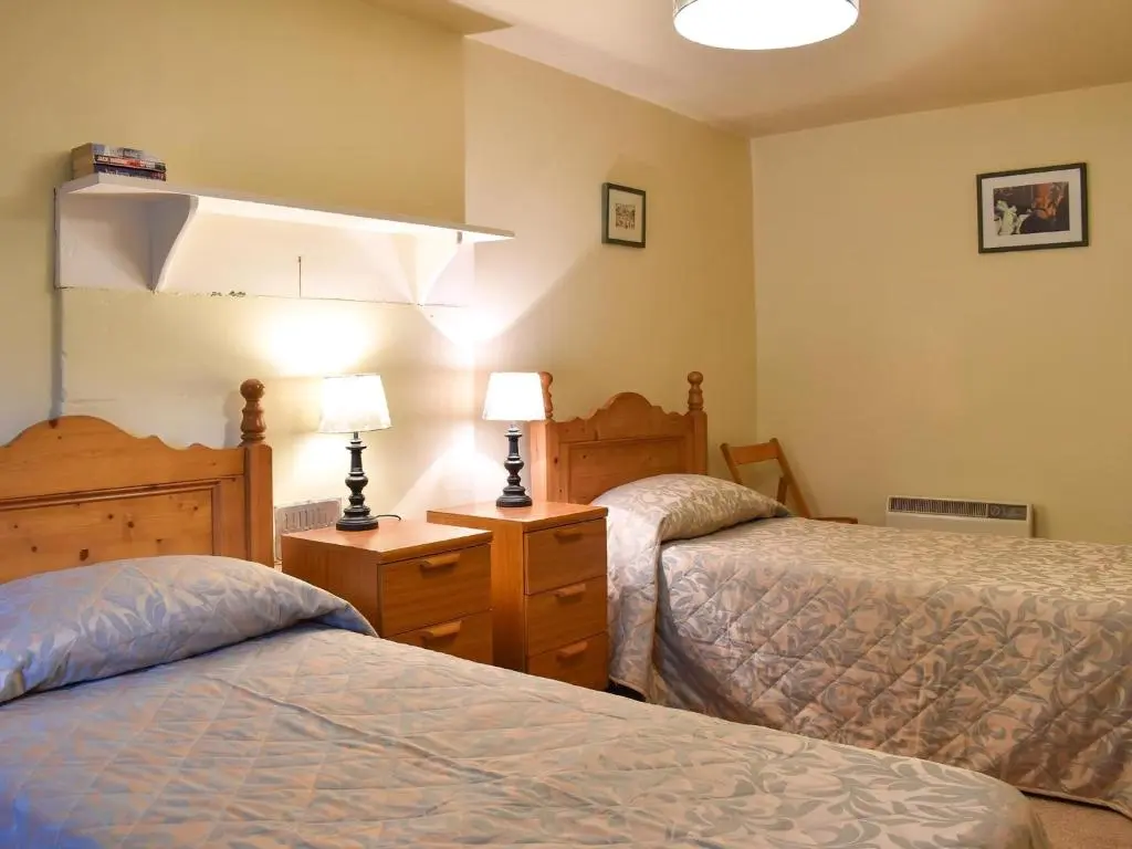 a hotel room with two beds and two lamps at Burnmouth in Balnaboth