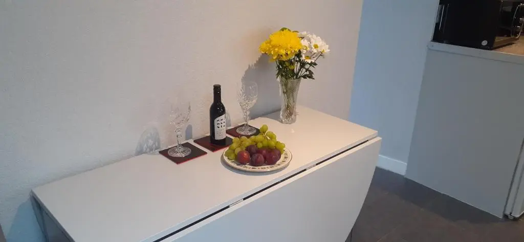 a table with a vase of flowers and a plate of fruit at The Treehouse by Airlie in Nairn
