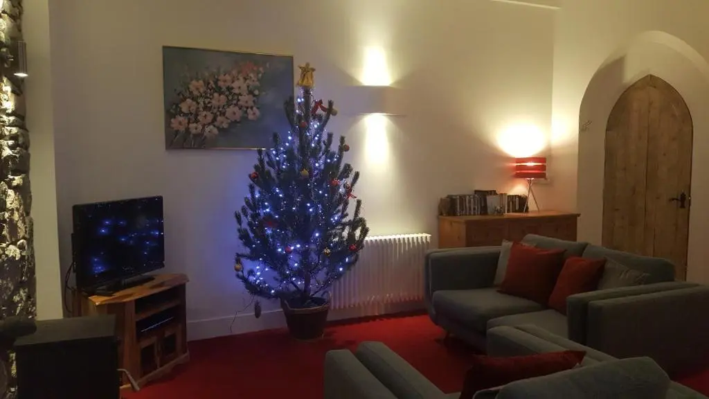 a living room with a blue christmas tree in it at The Old Convent Holiday Apartments in Fort Augustus