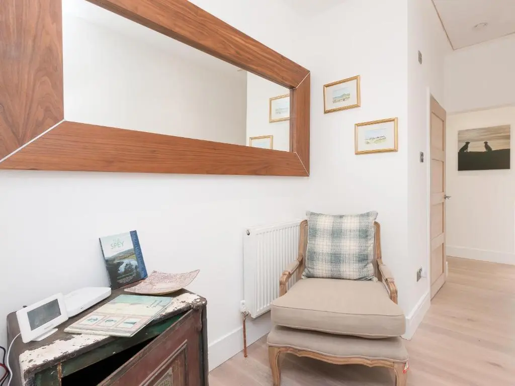 a room with a chair and a mirror on the wall at Inverspey in Kingston