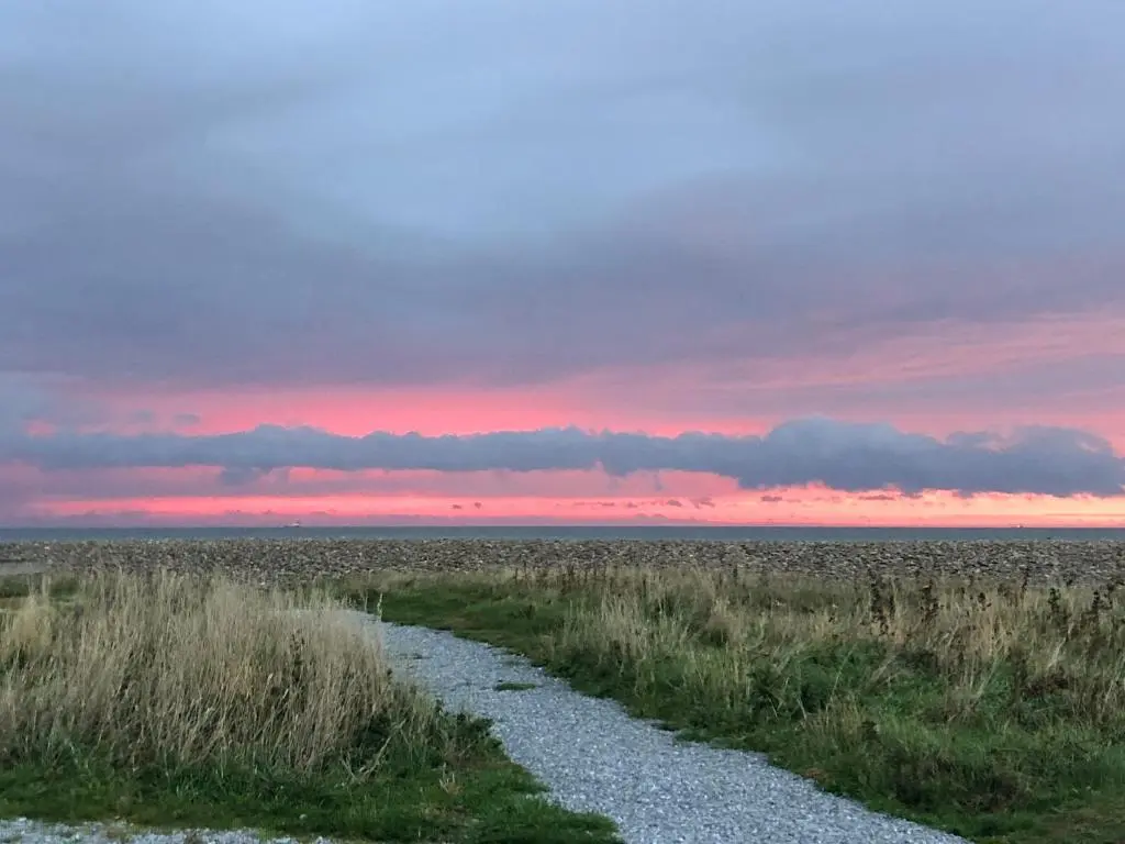 a sunset over a field with a gravel road at Inverspey in Kingston