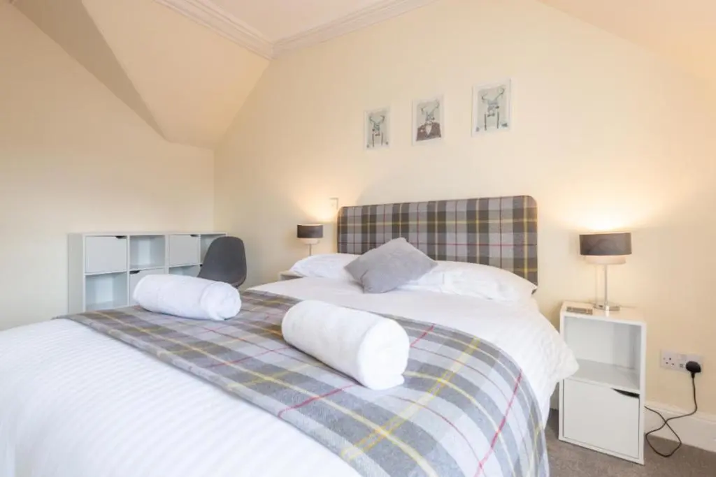 a bedroom with a large bed with two pillows at Aye Stay Home, city centre in Inverness