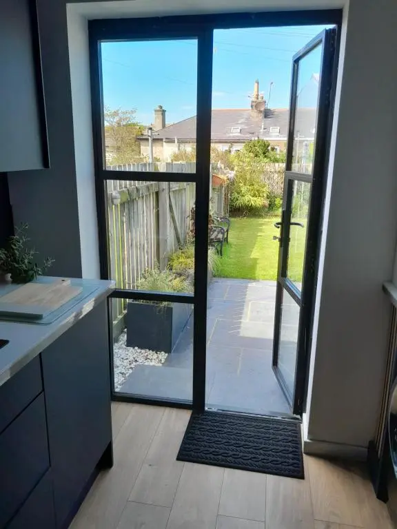 an open door with a view of a yard at WELCOMEHOUSE close to east beach, shops, restaurants and RAF base in Lossiemouth