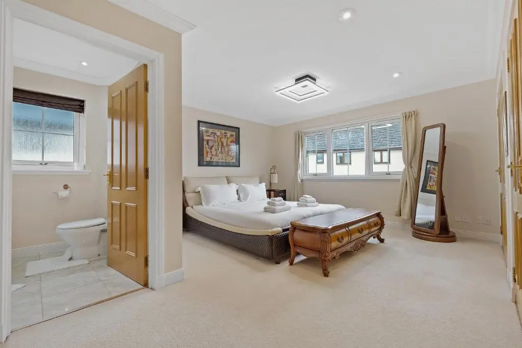 a bedroom with a bed and a toilet in it at Taigh d'Luxe in Inverness
