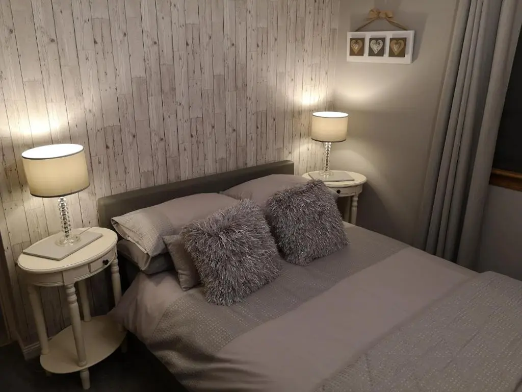 a bedroom with a bed with two lamps on it at Perfect Stay Apartments No.20 in Inverness