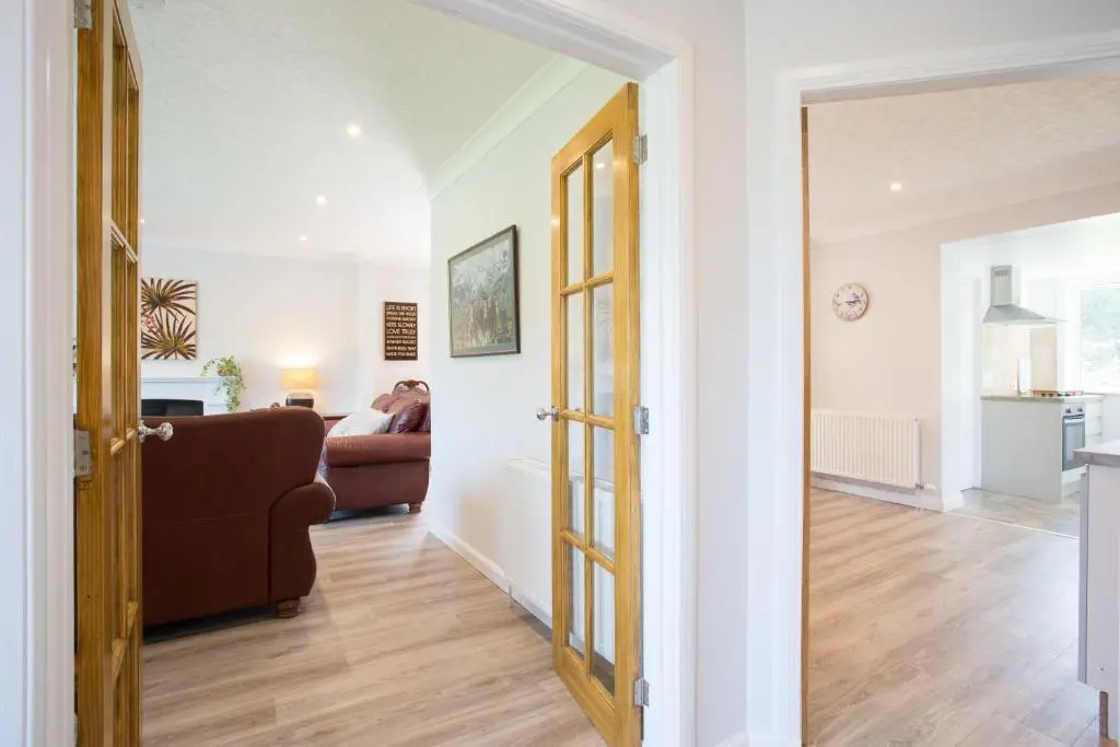 an open door to a living room with a couch at Juniper Hill Loch Achilty in Contin