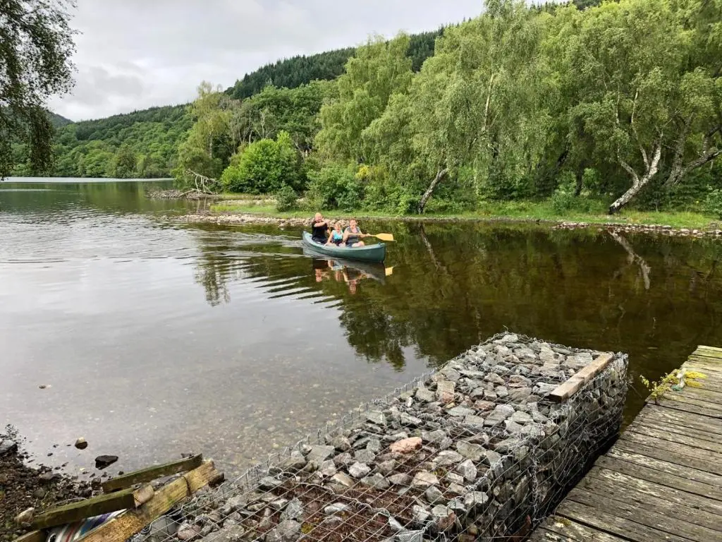 a group of people in a boat on a lake at Juniper Hill Loch Achilty in Contin