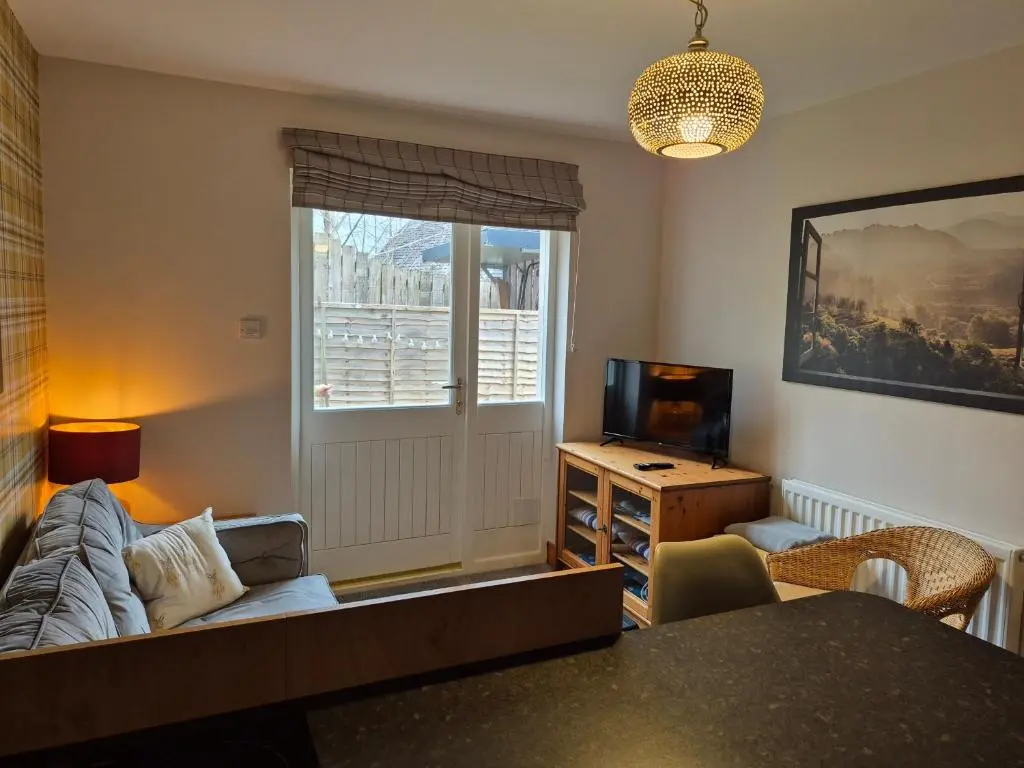 a living room with a couch and a television at The Studio in Drumnadrochit
