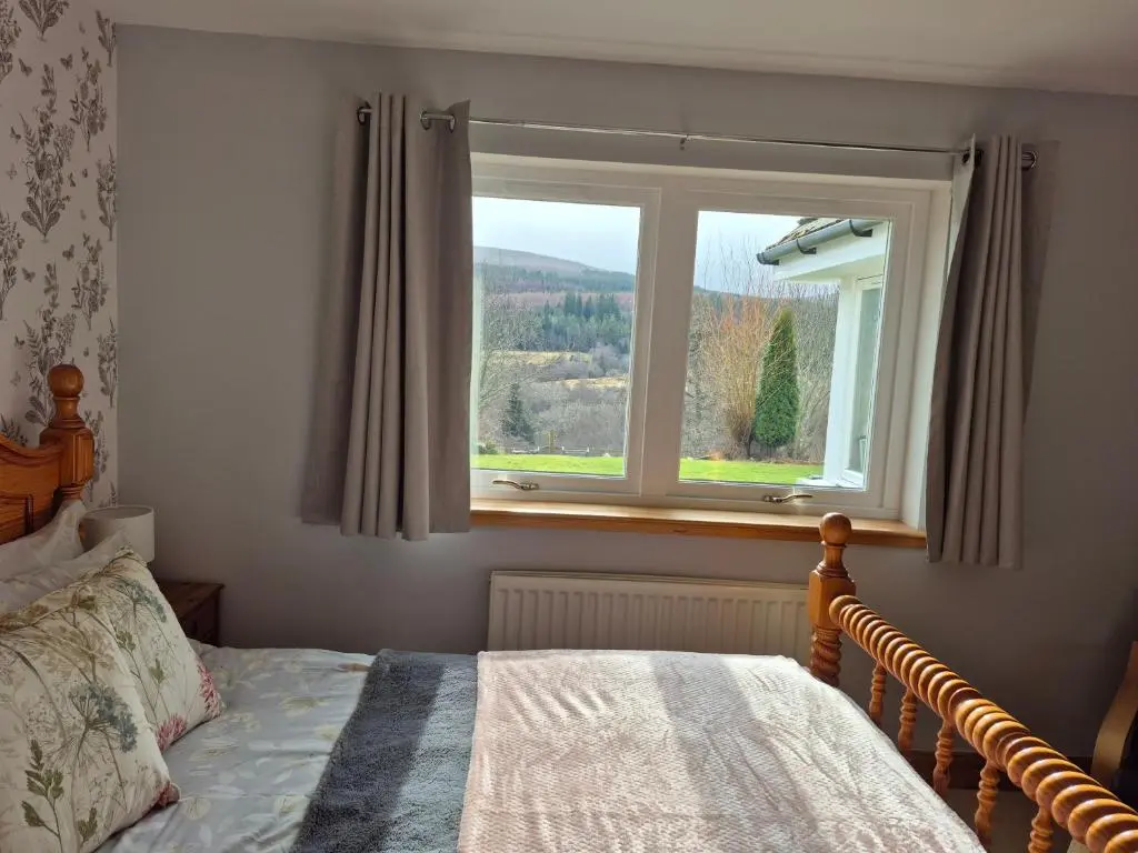 a bedroom with a bed and a window at The Studio in Drumnadrochit