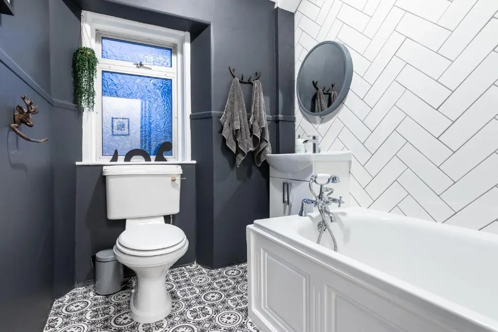 a bathroom with a toilet and a tub and a mirror at West of the Ness in Inverness