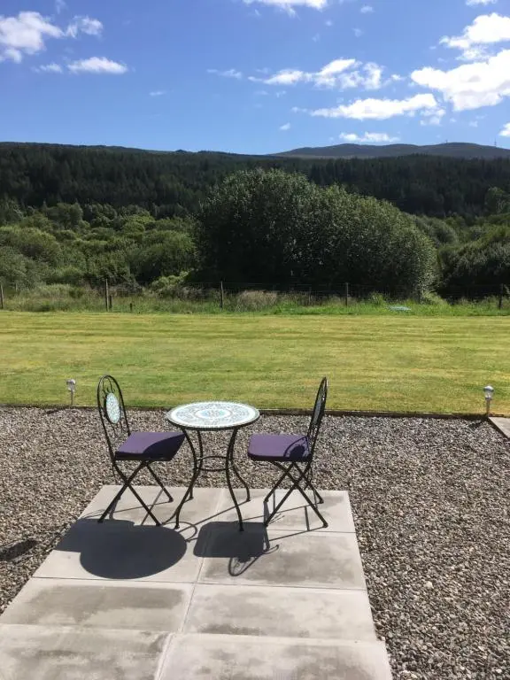 a table and two chairs with a view of a field at The Willows in Dalchreichart