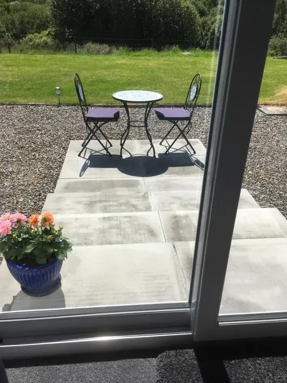 a patio with a table and chairs and a potted plant at The Willows in Dalchreichart